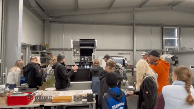 Workshop-Besucher betrachten Produktionsmaschinen und erhalten eine Demonstration der Technik.