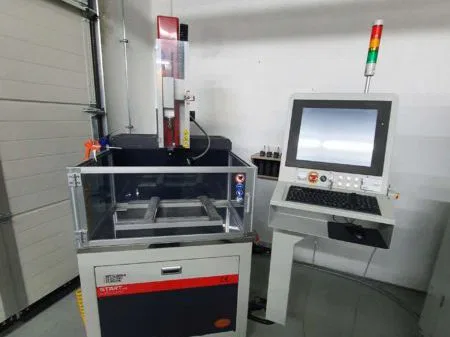 Industrial CNC machine with monitor and control panel in a workshop setting.