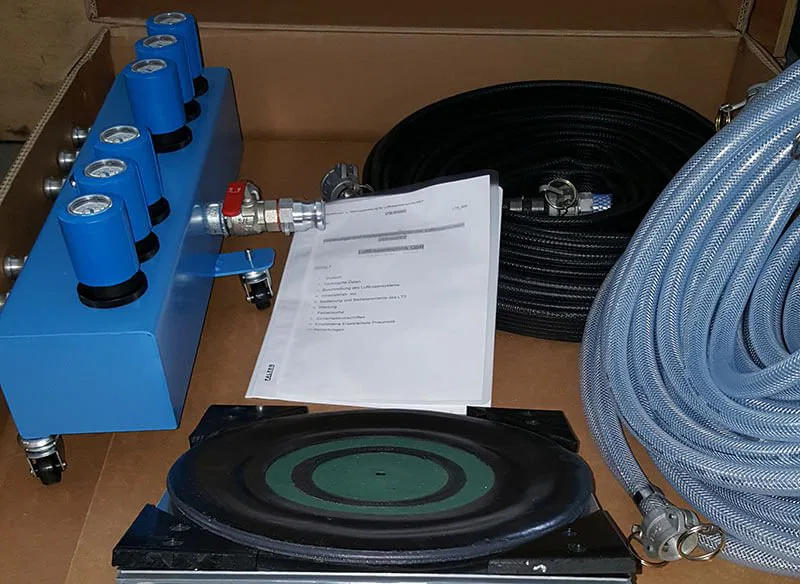 Blue hydraulic manifold and hoses with user manual for pressurized system operations.