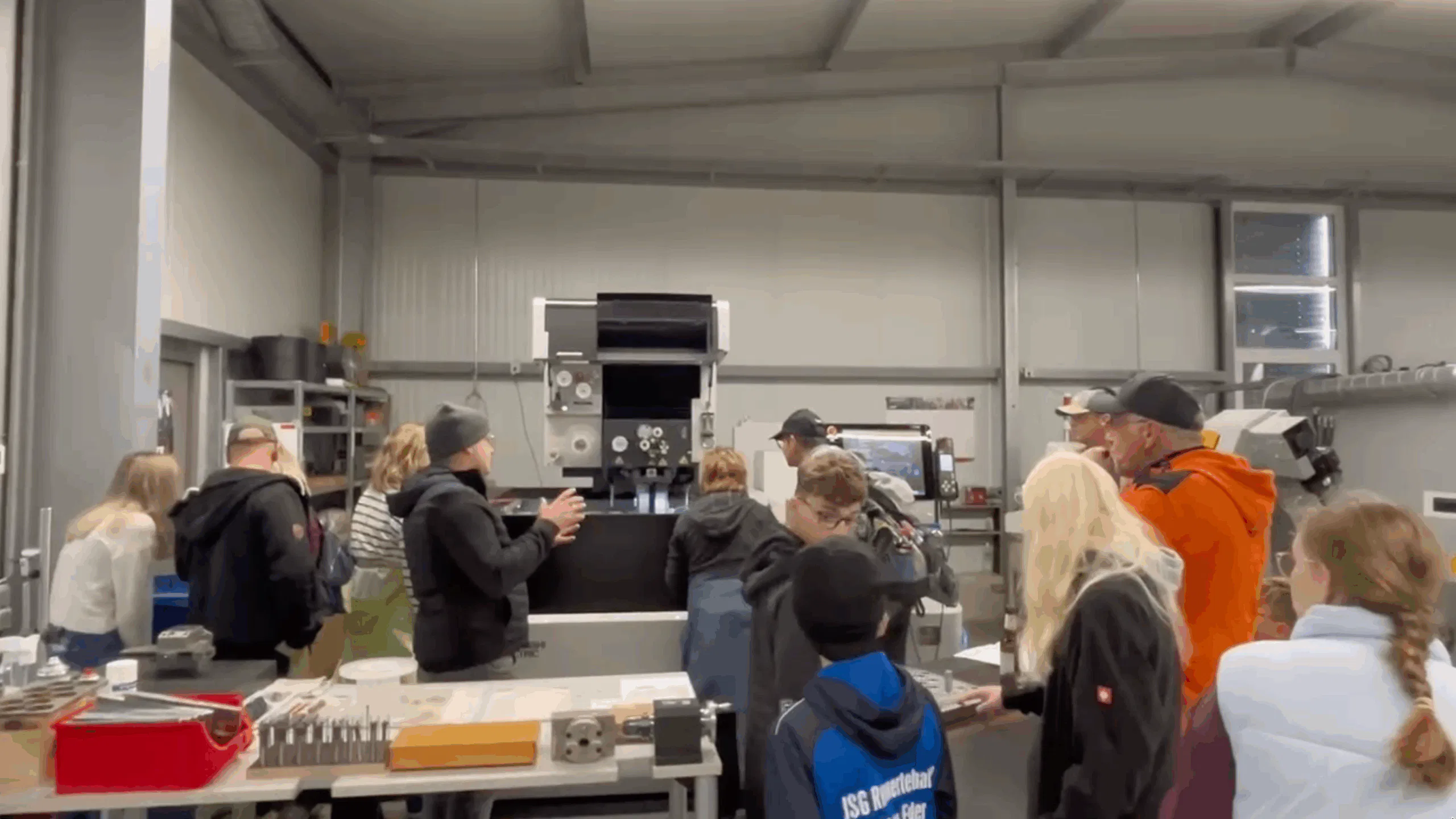 Workshop-Besucher betrachten Produktionsmaschinen und erhalten eine Demonstration der Technik.